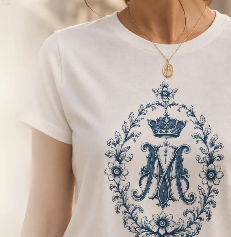 Detalhe do monograma floral azul na camiseta Mariae
